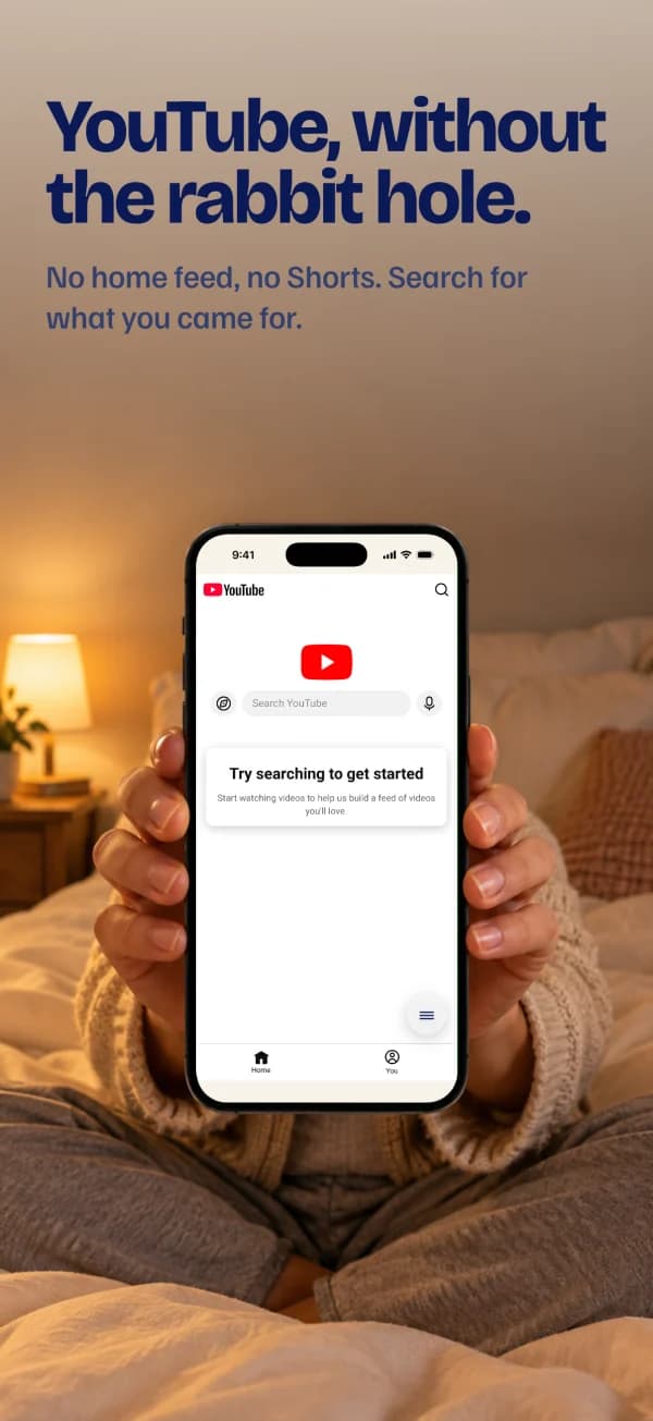 YouTube, without the rabbit hole. Someone in bed holds the phone; on screen, YouTube opens on search with no feed.